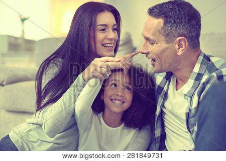 Beautiful Woman And Handsome Man Taking Good Care Of Their Adopted Daughter.