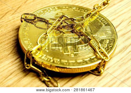 Closeup Of Golden Bitcoin In Golden Chains Laying On Wooden Background