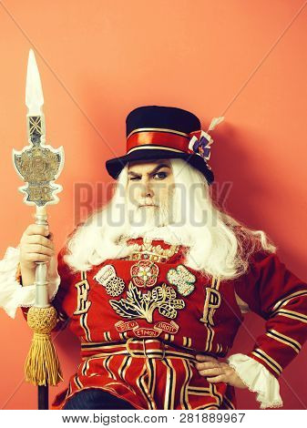 Frown Senior Man Beefeater Yeomen Warder Or Male Royal Guard Bodyguard In Uniform With Spear On Red 