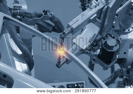 The Welding Robotic Machine Welding The Automotive Parts With Lighting Effect. Industrial 4.0 Concep