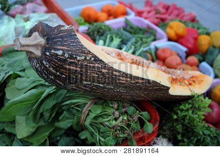 Green Pumpkin Slice Between Variety Of Vegetables And Fruits