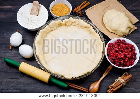 Pie Base In A Glass Round Form And Ingredients For Making Cake  - Flour, Egg, Cherry, Brown Sugar, C