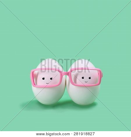 Ttwo Eggs In Pink Glasses Like Siamese Twins. Funny Character In Kawaii Style. Creative Easter Decor