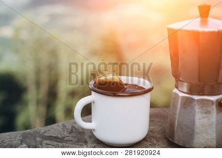 Cup Hot Coffee And Coffee Maker On Background Of Nature During The Sunset . Concept Adventure Active