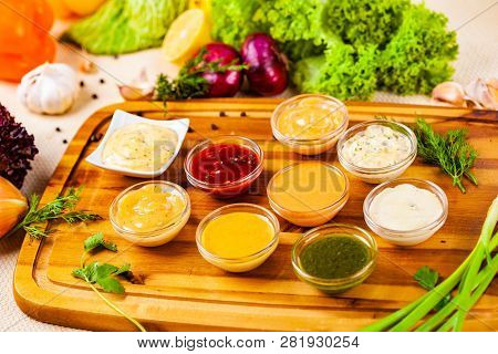 Different Sauces Assortment On Wooden Cutting Board