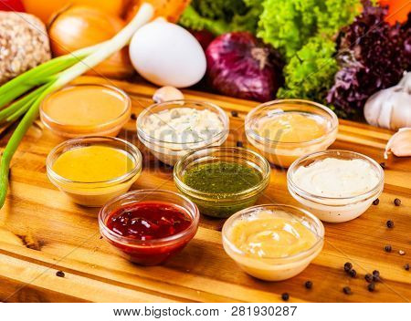 Different Sauces Assortment On Wooden Cutting Board