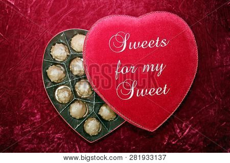 Valentines Day. Red Velvet Heart Shaped Valentines Day Chocolates Box.
On Burgundy Red Velvet background.  Text reads, Sweets for my Sweet
