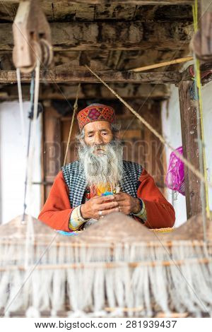 Kullu, Himachal Pradesh, India - August 09, 2018 : An Indian Old Man Makes A Traditional Sadu Weavin