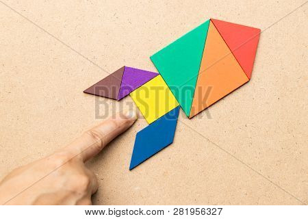 Color Tangram In Rocket Shape With Hand At The Base On Wood Background (concept For Startup, New Exp