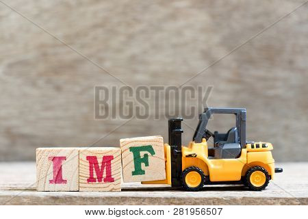 Toy Forklift Hold Letter Block F In Word Imf (abbreviation Of International Monetary Fund) On Wood B