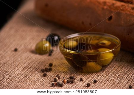 Fresh Bread Baguette With Olive Oil, Olives. Cheese And Rosemary On Wooden Background. Teasty Breakf