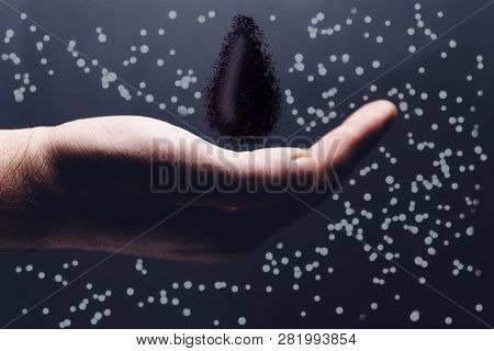Human Hand Holding Black Naphta Oil Drop. Mixed Media.