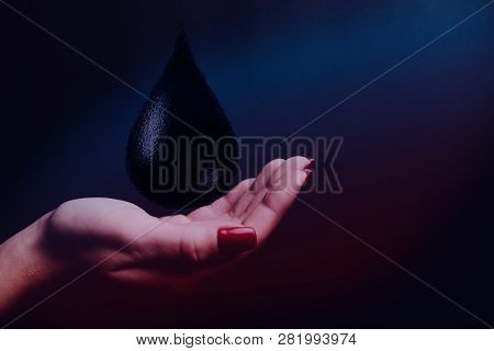 Human Hand Holding Black Naphta Oil Drop. Mixed Media.
