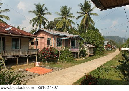 Traditional Colorful Hauses On Stilts In Dayak Tribe Village With Palm Trees Around, In Berau Distri