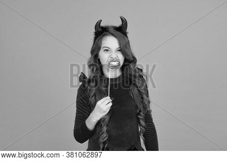 I Dont Bite Much. Little Girl Wear Halloween Red Devil Horns And Mouth Props. Small Child Dressed Fo