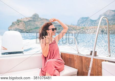 Woman In Hat And Dress Sailing On Boat In Clear Open Sea
