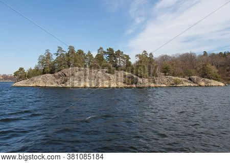 The View From Sea On A Rock With Connifer Trees, Sweden.