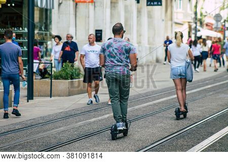 Reims France August 15, 2020 View Of Unidentified People Rolling With An Electric Scooter In The Str