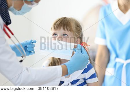 Female Doctor With Little Child Put On Protective Mask Portrait. Disease Prevention Concept