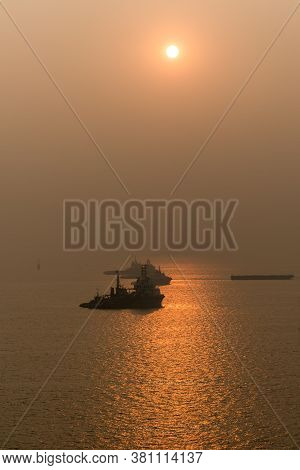 Beautiful Sunset On Sea With Solar Path On Waves In Orange Colors And The Silhouette Of Ships Anchor