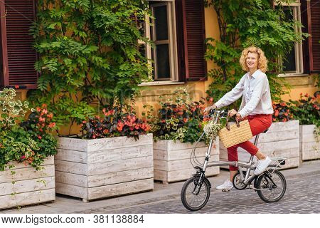 Portrait Of Romantic Mature Slim Blonde Woman In White Shirt Red Pants Enjoying, Walking Outdoor In 