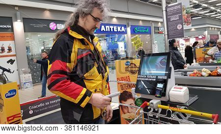Russia, St. Petersburg 14.03.2020 Buyer With A Hand Scanner At The Self-checkout Counter In A Superm