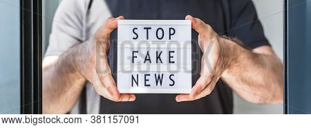 Fake News Infodemics During Covid-19 Pandemic Concept. Man Hands Holding Lightbox With Text Stop Fak