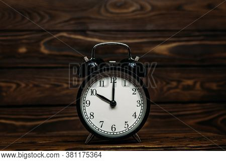 Clock On A Wooden Background. The Clock Shows The Time Of Ten O'clock In The Afternoon. Clock Showin