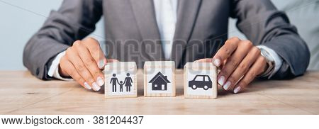 Horizontal Crop Of Woman Touching Wooden Cubes With Family, Car And House