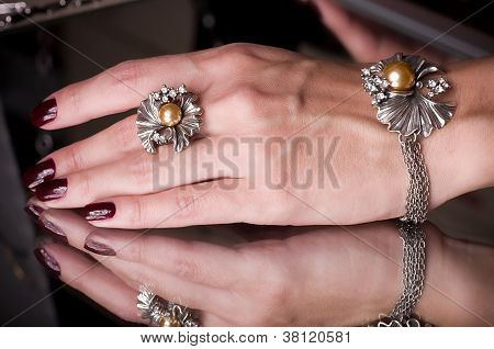 Main avec bijoux doré sur fond noir