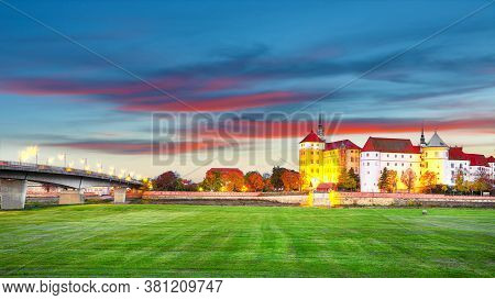 Fantastic Morning View Of Hartenfels Castle On Banks Of The Elbe. Dramatic Sunrise. Location: Torgau