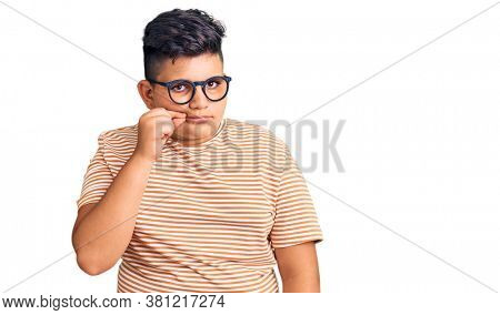 Little boy kid wearing casual clothes and glasses mouth and lips shut as zip with fingers. secret and silent, taboo talking 