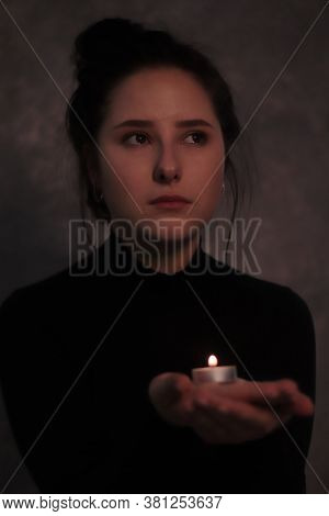 Dark Portrait Of A Sad Brunette Almost Burst Into Tears Holding Candle