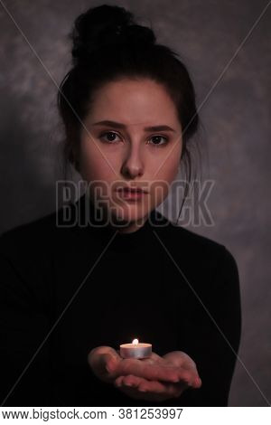 Dark Portrait Of A Sad Brunette Almost Burst Into Tears Holding Candle