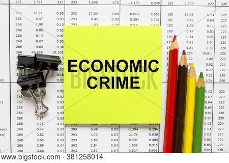 Text Economic Crime On Financial Tables With Color Pencils And Paper Clips