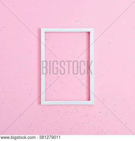 Minimal Holiday Concept. Square White Frame On Pink Paper Background Covered With Sequins With Copy 