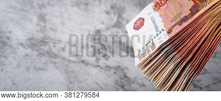 Russian Cash Banknotes Of Five Thousand Rubles, The Bundle Hangs On A Gray Background.