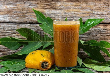 Papaya Juice In A Setting With Fresh Fruits On A Wooden Background.