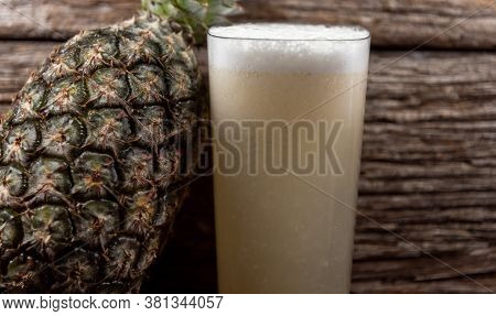 Natural Juice And Fresh Fruits Of Pineapple (ananas Comosus) On Woody Background