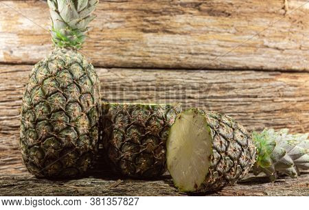 Halved Pineapple Fruit On Woody Background