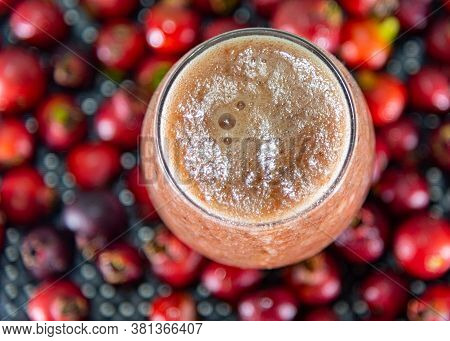 Glass Bowl Of Araçá Juice (psidium Cattleianum) With Fresh Fruits Around It
