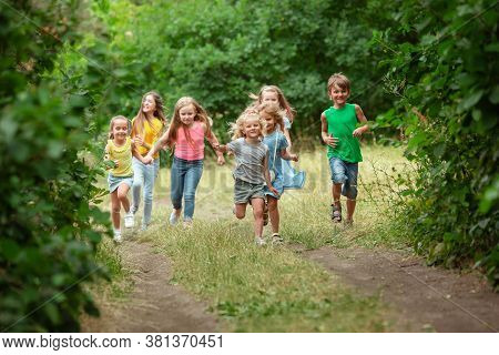 Happiness. Kids, Children Running On Green Forest. Cheerful And Happy Boys And Girs Playing, Laughti