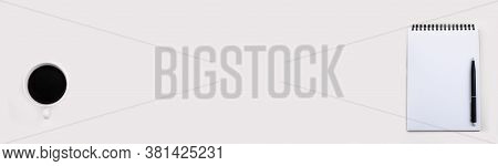 White Notepad With Black Pen And Cup Of Coffee On Light Table,