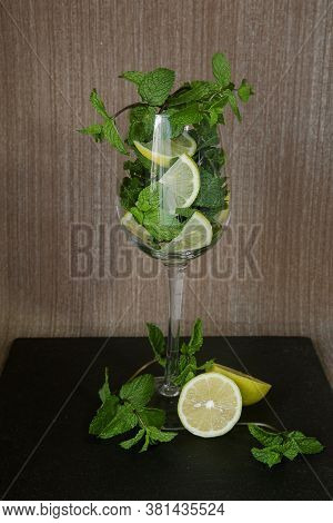 Sliced Lemon With Mint Sprigs In A Long Stemmed Glass