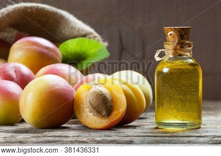 Glass Bottle Of Apricot Seed Kernel Oil ( Prunus Armeniaca Oleum ) With Fresh Ripe Apricot Fruits On