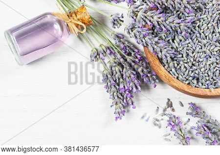 Glass Bottle Of Lavender Essential Oil With Fresh Lavender Flowers And Dried Lavender Seeds On  Rust