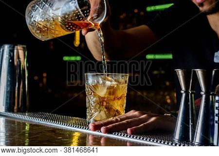 Bartender Pouring Cocktail Over Ice. Old Fashion Cocktail Serving