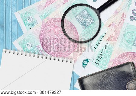 100 Czech Korun Bills And Magnifying Glass With Black Purse And Notepad. Concept Of Counterfeit Mone
