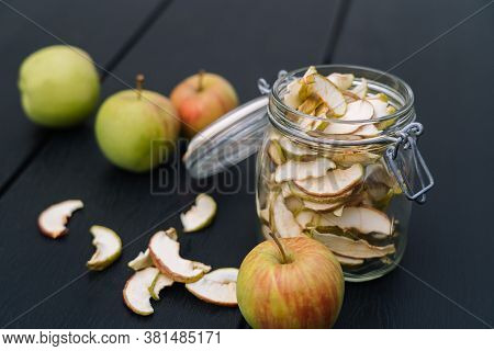 Dried Apple Slices In Open Glass Jar. Homemade Organic Dried Apple Chips With Fresh Apple On Black T