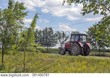 Aradac, Serbia, July 06, 2020. A Tractor That Travels On A Local Road From One Field To Another.